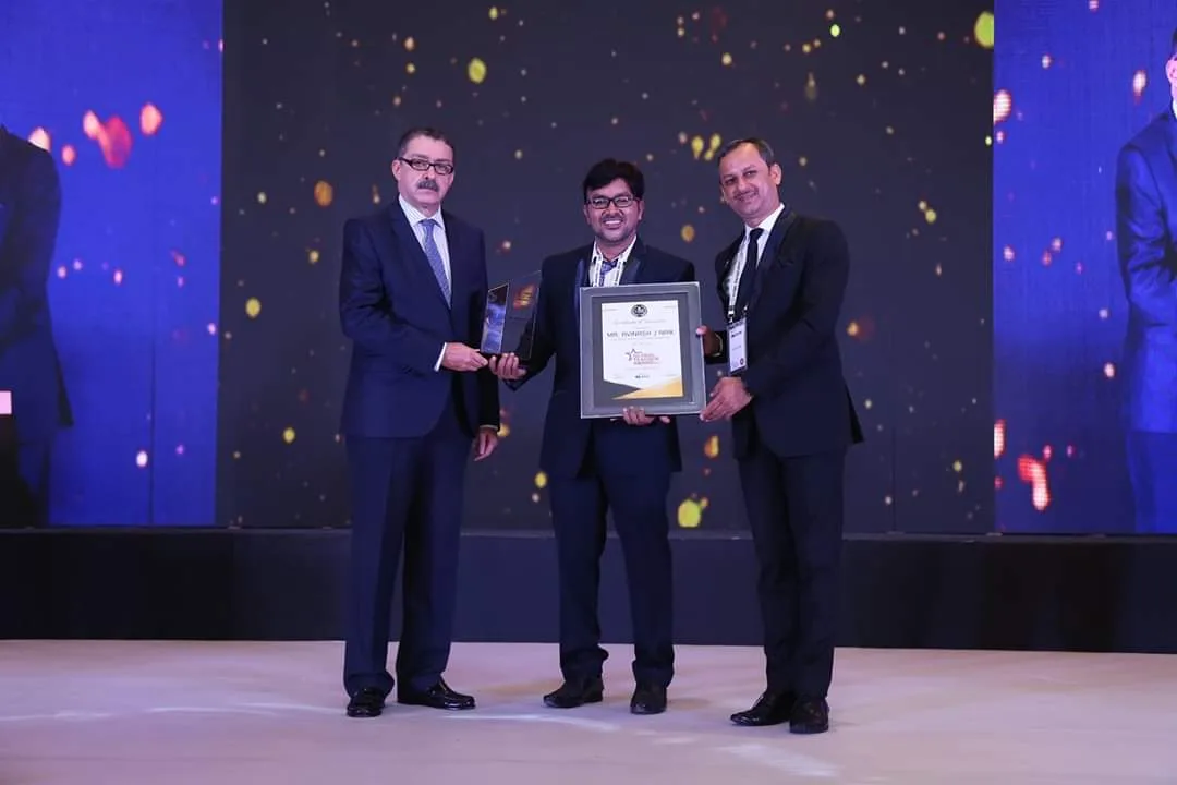 Avinash J Naik receiving an award on stage